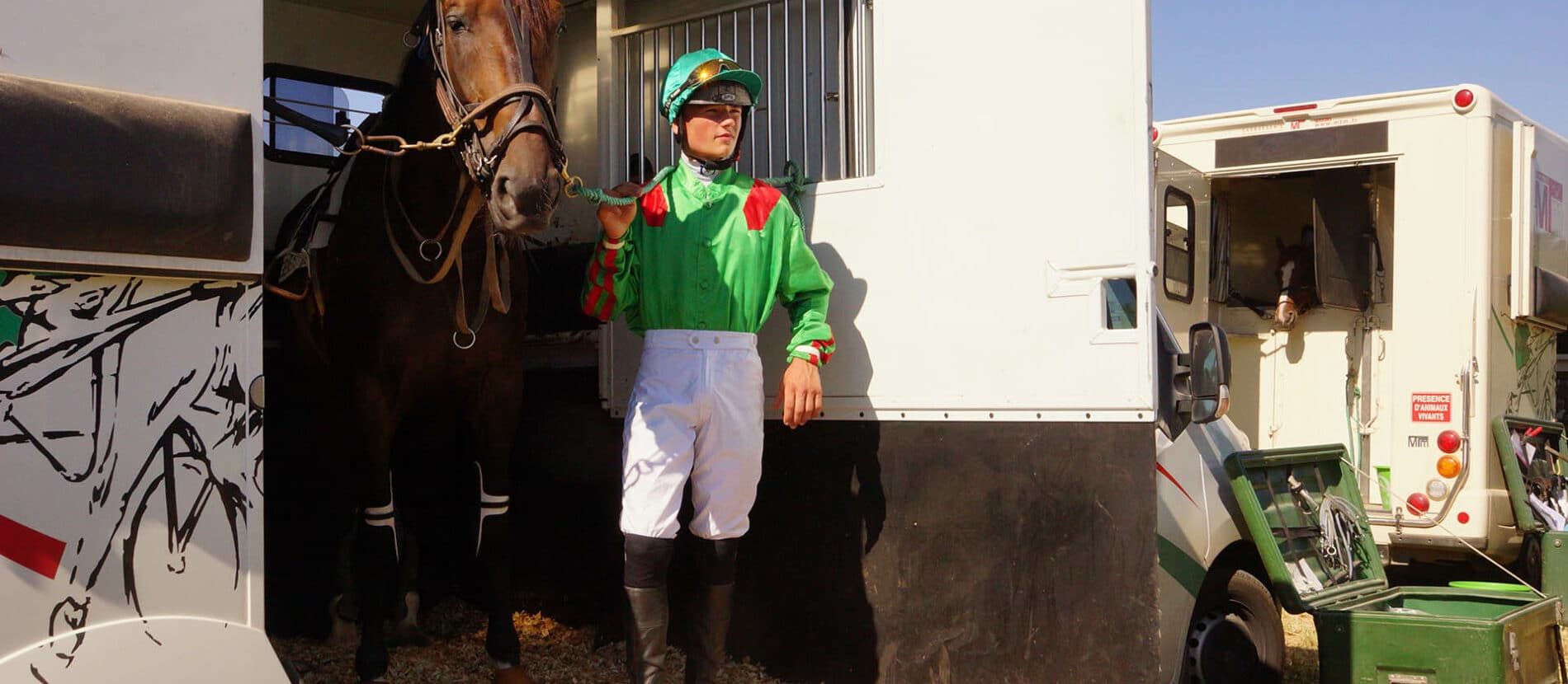 Jockey avec son cheval dans un van