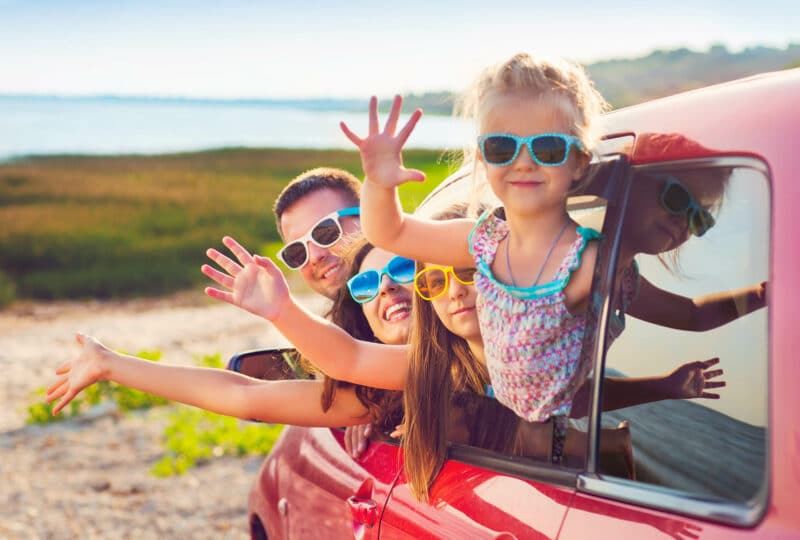 Famille saluant par la fenêtre d’une voiture