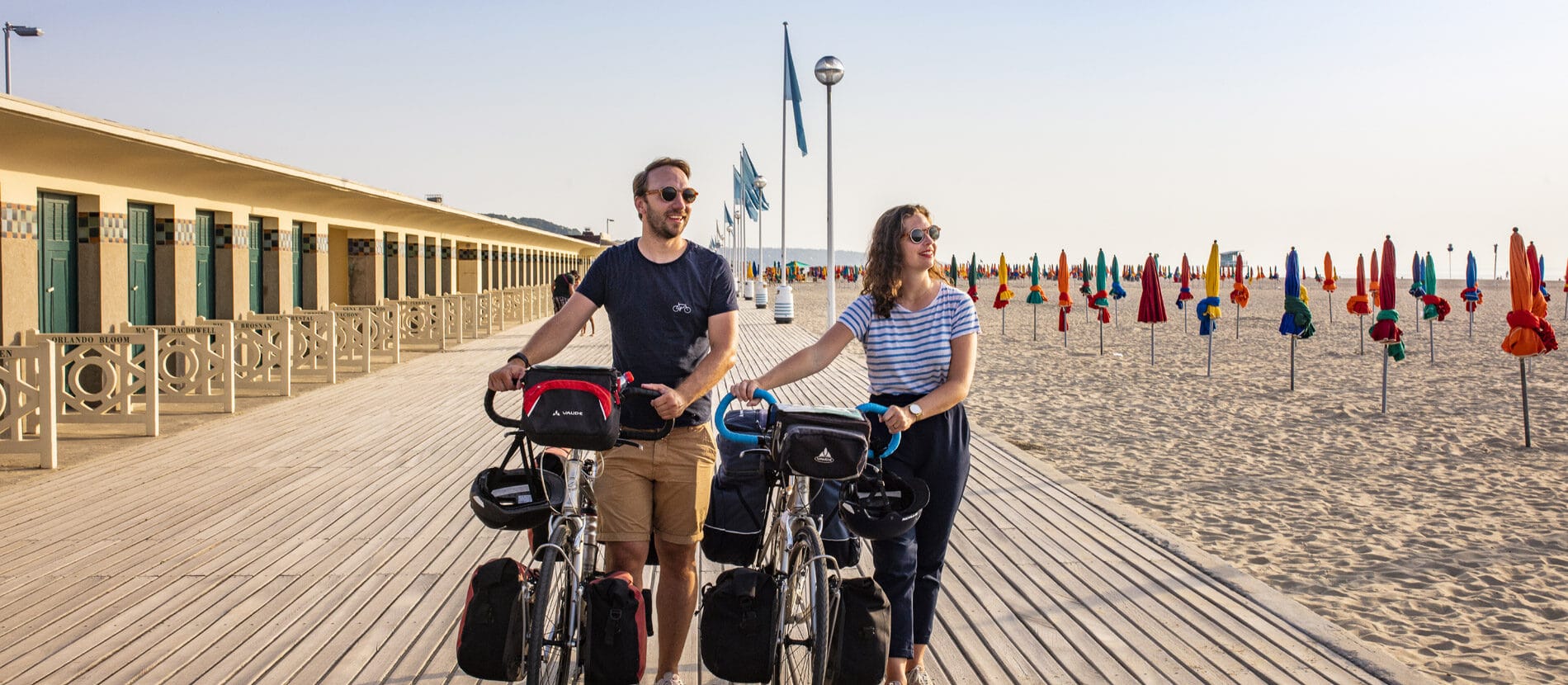 Couple en balade à vélo sur les planches de Deauville