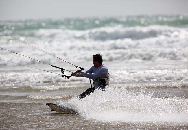 Homme pratiquant du kite surf en mer