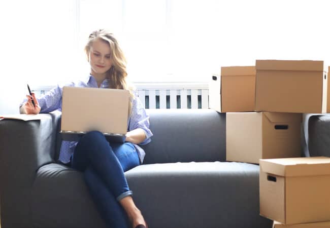 Femme dans son canapé entourée de cartons