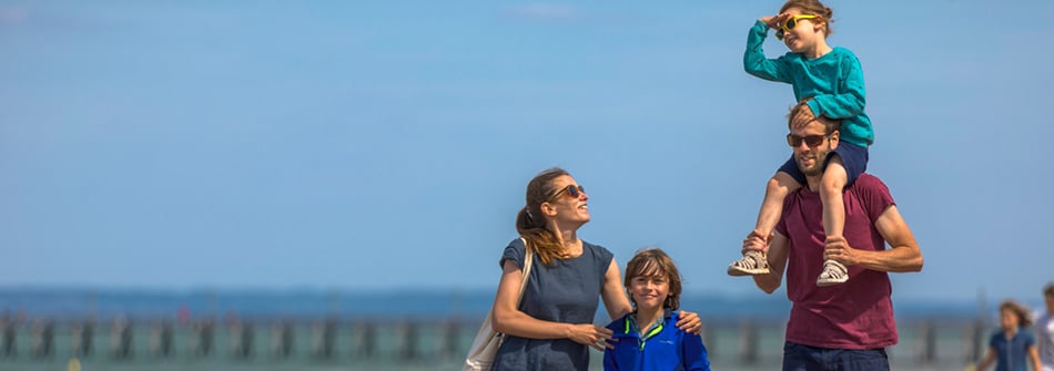 Balade en famille sur la digue le long de la plage