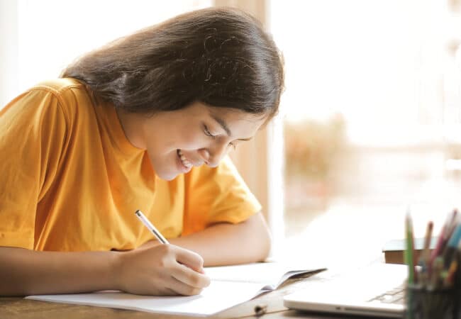 Femme entrain d'écrire à son bureau