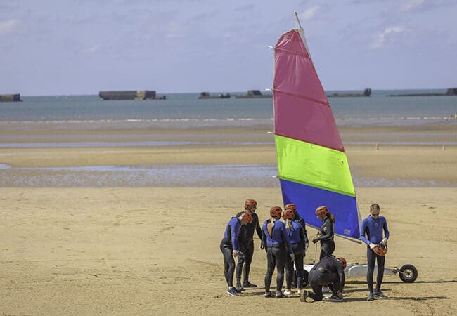 Baptême de char à voile pour un groupe d'hommes et femmes sur une plage du Calvados