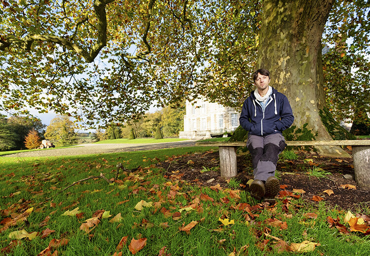 Homme assis sur un banc dans un jardin