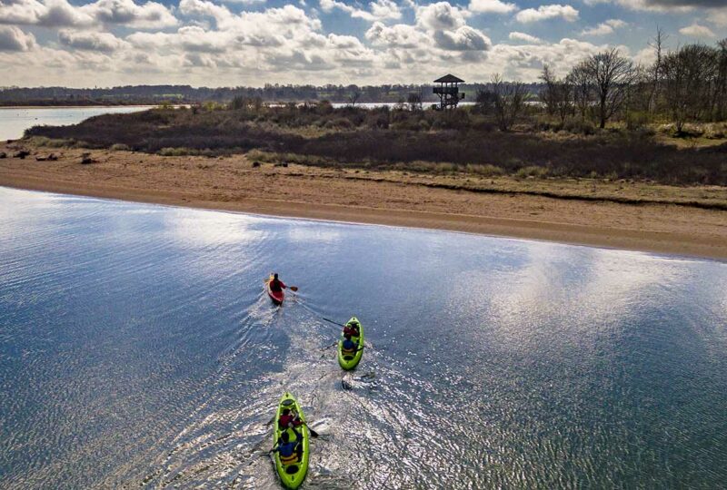 Kayaks bi-places et simple en train de naviguer dans la Baie de l'Orne avec vue sur l'observatoire de la Pointe du Siège